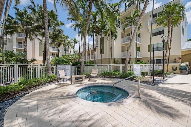 view of pool featuring a hot tub and fence