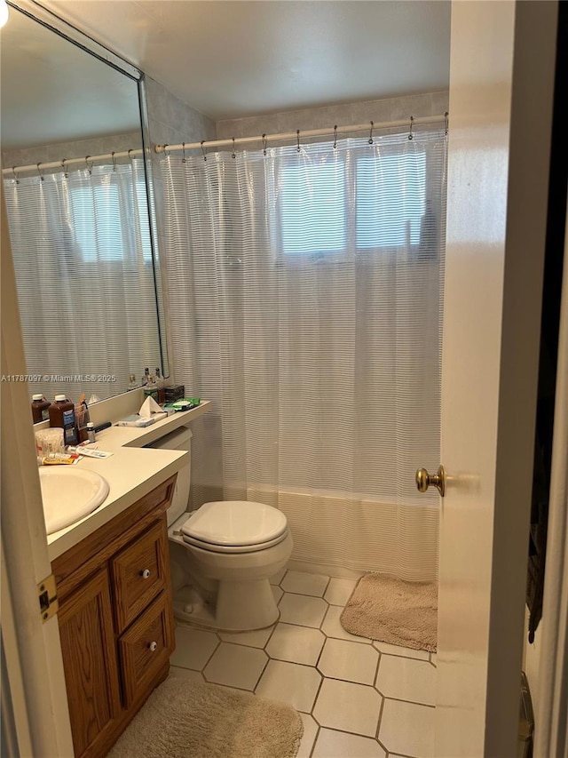 bathroom with shower / bath combination with curtain, vanity, tile patterned flooring, and toilet