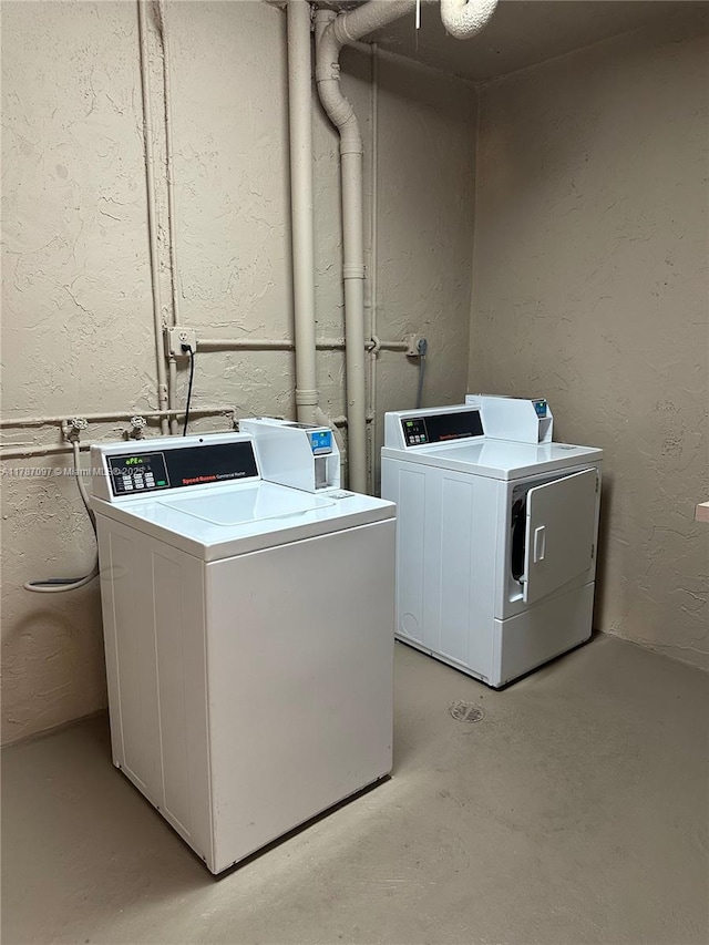 common laundry area featuring a textured wall and separate washer and dryer