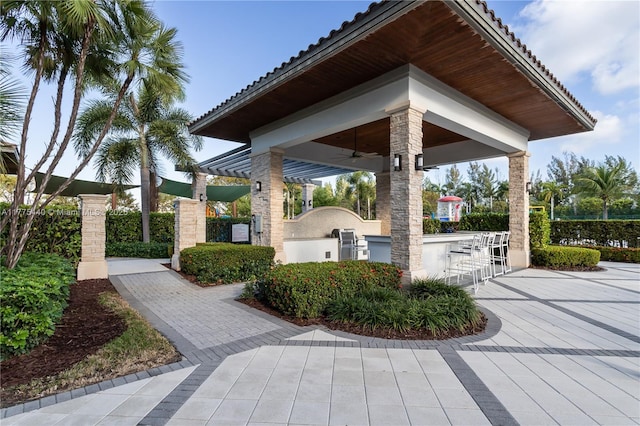 view of home's community featuring exterior kitchen, fence private yard, and an outdoor bar