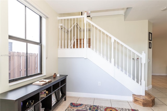 stairway with tile patterned floors and baseboards