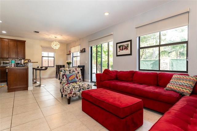 living area featuring an inviting chandelier, recessed lighting, light tile patterned floors, and a healthy amount of sunlight