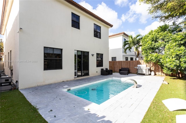 back of house with a patio area, a fenced backyard, a fenced in pool, and stucco siding