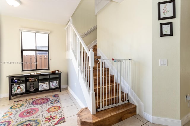 staircase featuring baseboards and tile patterned floors