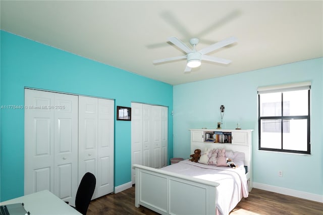 bedroom featuring two closets, a ceiling fan, baseboards, and dark wood-style flooring