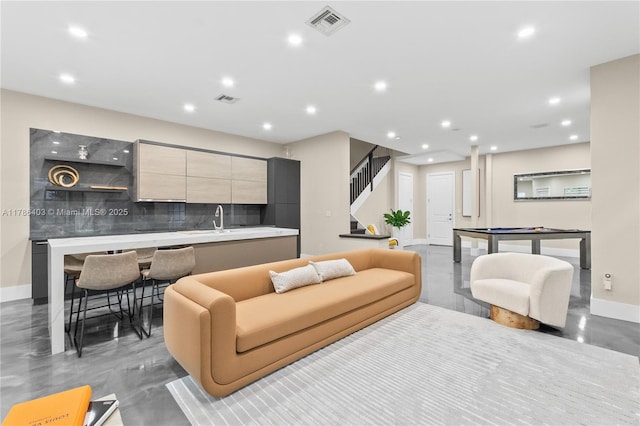 living area with baseboards, visible vents, recessed lighting, and stairs