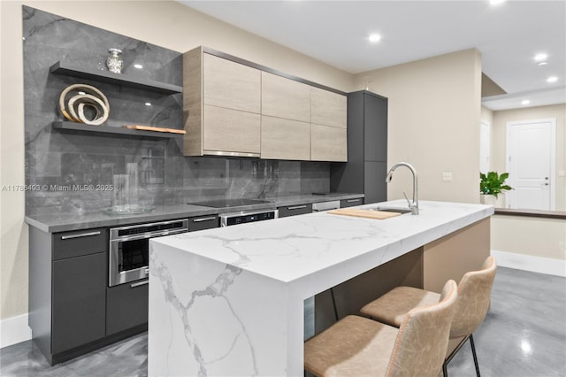 kitchen featuring light stone counters, decorative backsplash, oven, modern cabinets, and recessed lighting