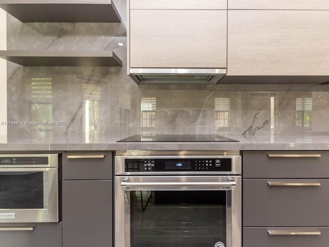 kitchen with stainless steel oven, gray cabinets, and black electric cooktop