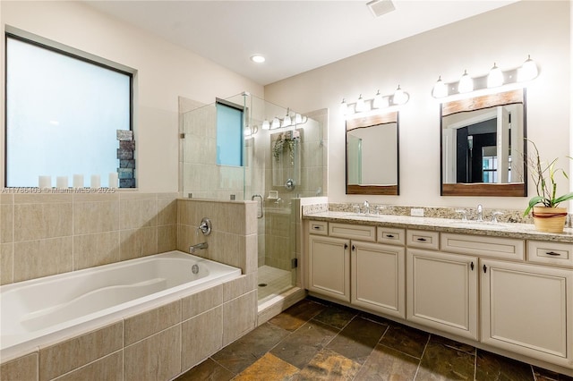 bathroom featuring a garden tub, a sink, a stall shower, double vanity, and visible vents
