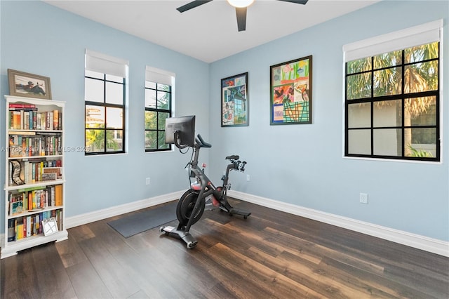 exercise area featuring baseboards, a ceiling fan, and wood finished floors