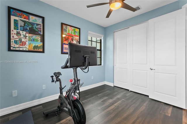 workout room with dark wood finished floors, visible vents, baseboards, and ceiling fan