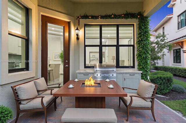 view of patio with a fire pit, an outdoor kitchen, and area for grilling