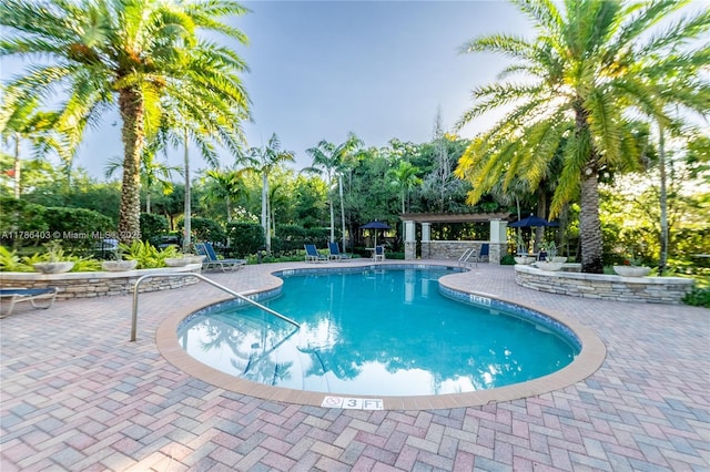 community pool with a gazebo and a patio area