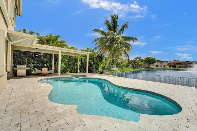 5337 SW 131st Ter, Miramar, FL 33027 - view of pool featuring a patio, a fenced backyard, a pool with connected hot tub, and a water view