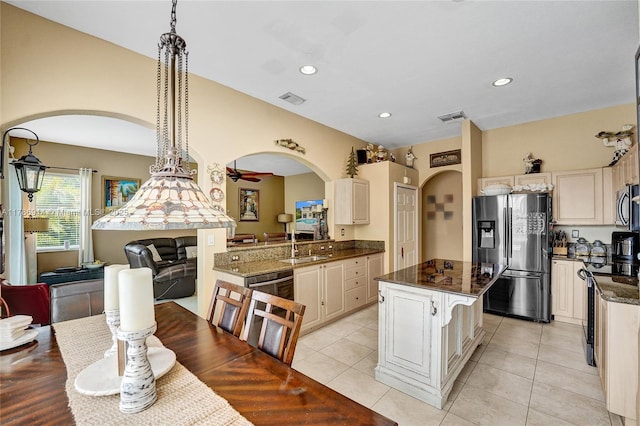 5337 SW 131st Ter, Miramar, FL 33027 - kitchen featuring stainless steel appliances, arched walkways, a kitchen island, recessed lighting, and dark stone counters