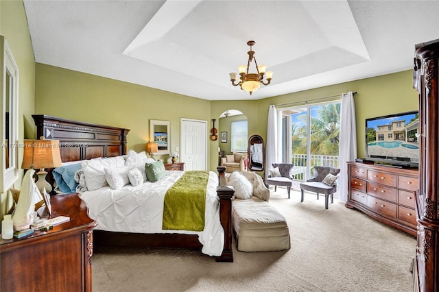 5337 SW 131st Ter, Miramar, FL 33027 - bedroom featuring a tray ceiling, carpet, arched walkways, a chandelier, and access to exterior