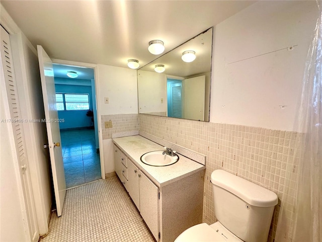 1001 Hillcrest Ct Unit 306, Hollywood, FL 33021 - half bathroom with tile patterned flooring, a wainscoted wall, toilet, vanity, and tile walls