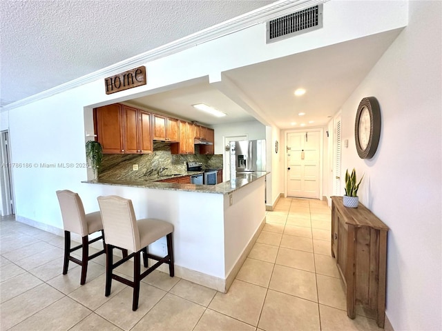 1001 Hillcrest Ct Unit 306, Hollywood, FL 33021 - kitchen with stainless steel appliances, a peninsula, visible vents, backsplash, and light tile patterned floors