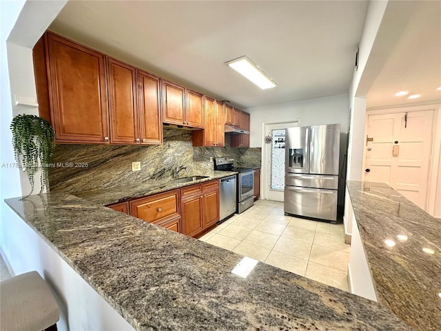 1001 Hillcrest Ct Unit 306, Hollywood, FL 33021 - kitchen featuring dark stone counters, light tile patterned floors, appliances with stainless steel finishes, backsplash, and under cabinet range hood