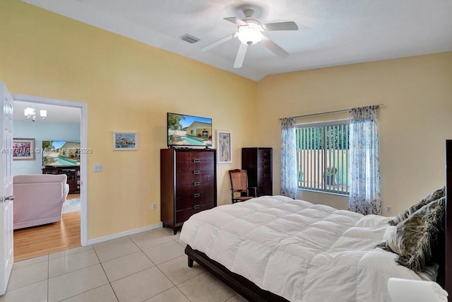 bedroom featuring vaulted ceiling, visible vents, baseboards, ceiling fan, and light tile patterned floors
