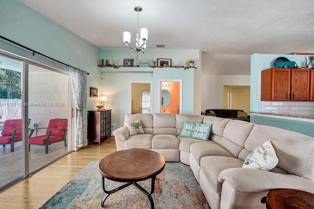 living area featuring a notable chandelier, visible vents, and light wood-type flooring