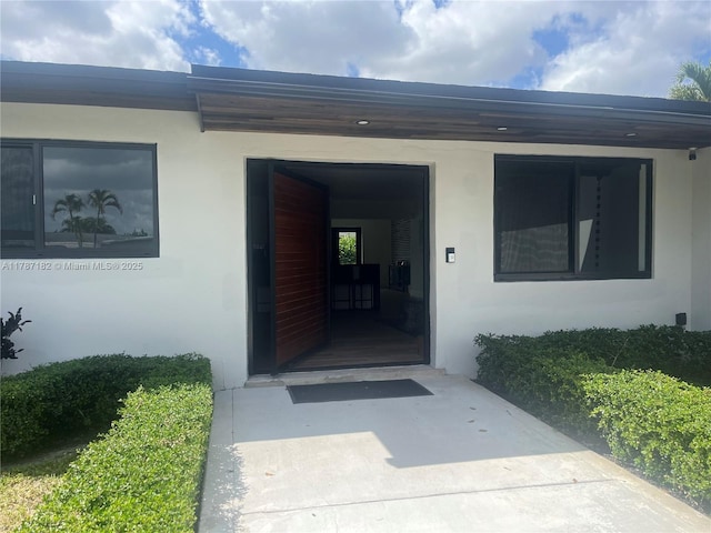 doorway to property featuring stucco siding