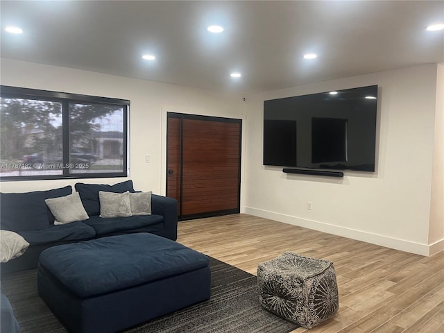 living room featuring baseboards, recessed lighting, and wood finished floors