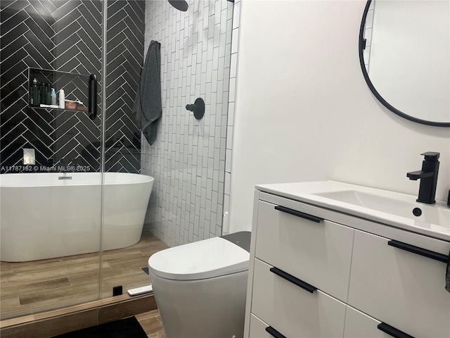 full bath featuring vanity, toilet, tile walls, wood finished floors, and a stall shower