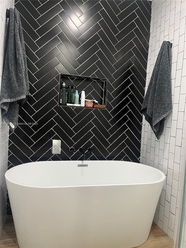 full bathroom featuring a freestanding bath and tile walls