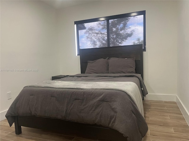 bedroom featuring baseboards and wood finished floors