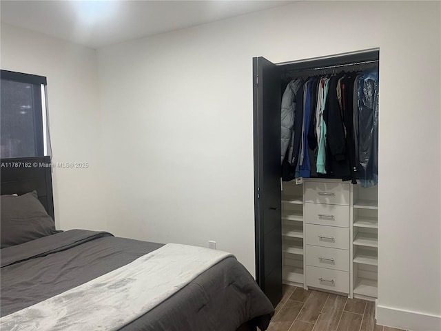 bedroom featuring baseboards and wood finished floors