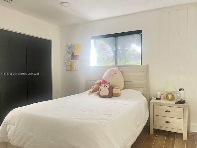 bedroom with visible vents and dark wood finished floors