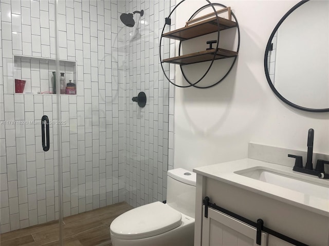 full bathroom with vanity, a stall shower, toilet, and wood finished floors