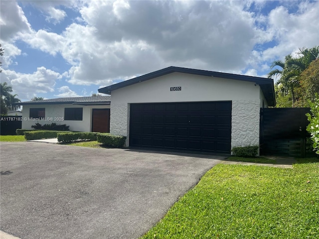 single story home with a garage, stucco siding, and driveway