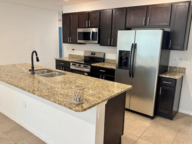 749 SE Karrigan Ter, Port St Lucie, FL 34983 - kitchen with appliances with stainless steel finishes, a sink, light tile patterned flooring, light stone counters, and baseboards