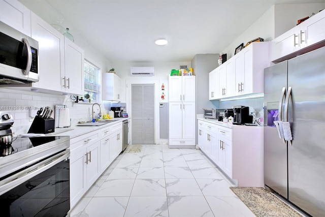 121 E Walnut St, Avon Park, FL 33825 - kitchen with stainless steel appliances, a sink, light marble finish floors, light countertops, and a wall unit AC
