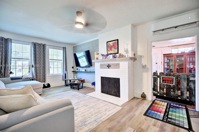 121 E Walnut St, Avon Park, FL 33825 - living area featuring a wall mounted AC, wood finished floors, a ceiling fan, and a fireplace