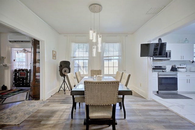 121 E Walnut St, Avon Park, FL 33825 - dining area with a wall unit AC, light wood-style floors, baseboards, and ornamental molding
