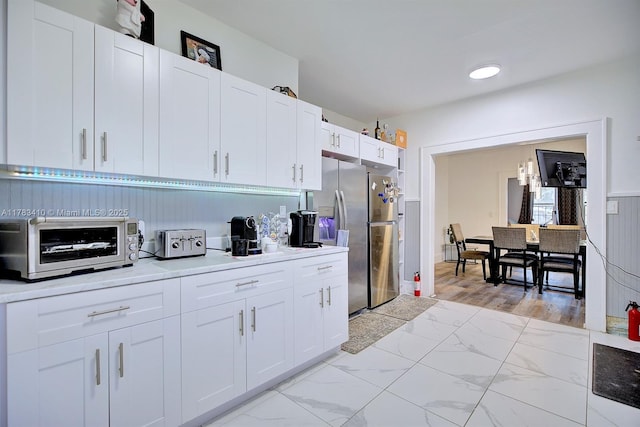 121 E Walnut St, Avon Park, FL 33825 - kitchen with stainless steel fridge, white cabinets, and light marble finish floors