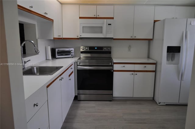 kitchen with a sink, light countertops, a toaster, white cabinets, and white appliances