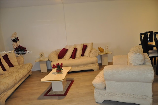 living area with baseboards and wood finished floors