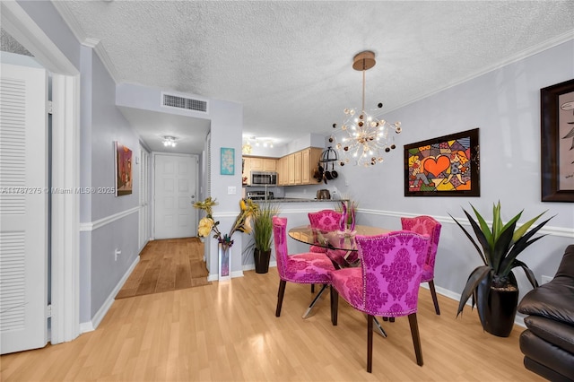 1280 S Alhambra Cir Unit 1207, Coral Gables, FL 33146 - dining room with light wood-style floors, a textured ceiling, and a chandelier