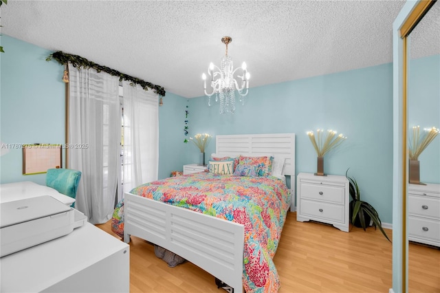 1280 S Alhambra Cir Unit 1207, Coral Gables, FL 33146 - bedroom with a chandelier, light wood-style flooring, and a textured ceiling