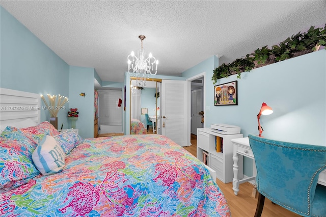 1280 S Alhambra Cir Unit 1207, Coral Gables, FL 33146 - bedroom with a chandelier, light wood-style floors, a closet, and a textured ceiling