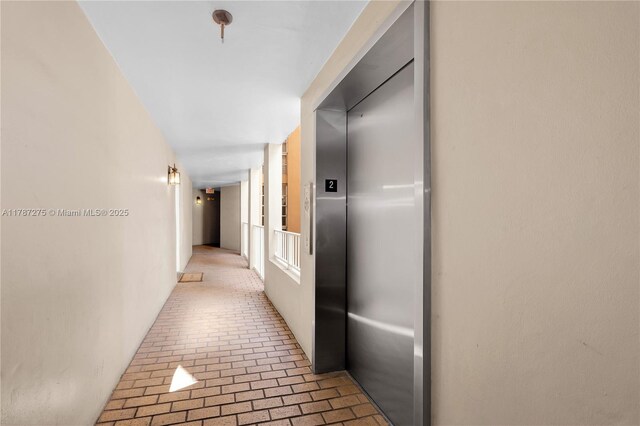 1280 S Alhambra Cir Unit 1207, Coral Gables, FL 33146 - corridor featuring brick floors and elevator