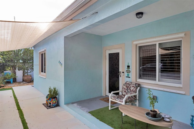 property entrance featuring stucco siding and a patio area