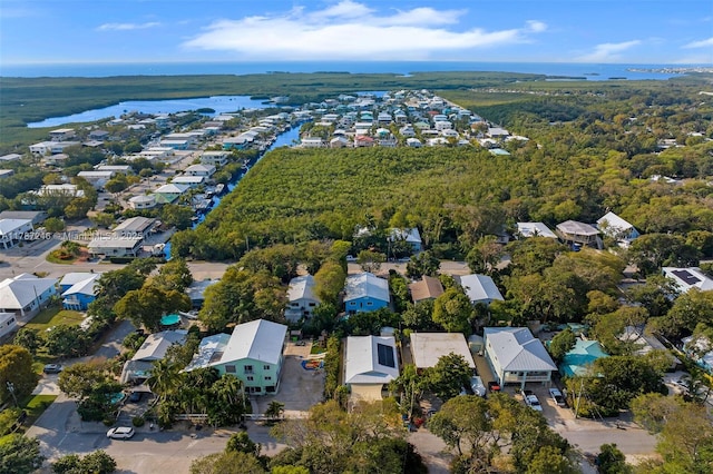 aerial view featuring a water view, a residential view, and a wooded view