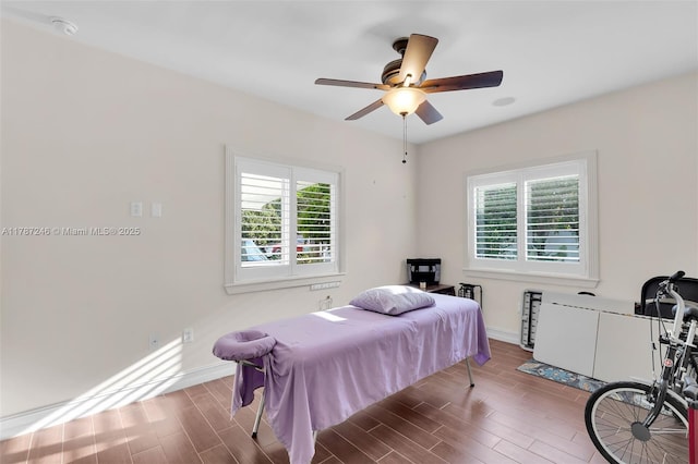 bedroom with baseboards, a ceiling fan, and wood finished floors