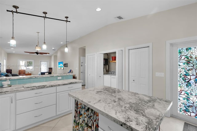 kitchen featuring lofted ceiling, open floor plan, ceiling fan, and washer and clothes dryer