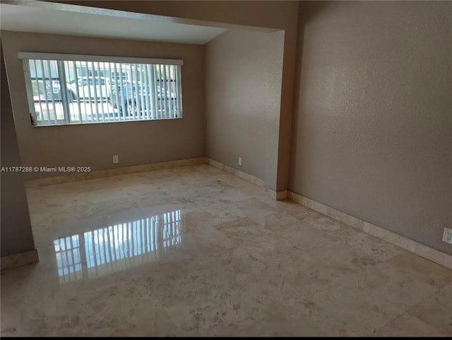 spare room featuring baseboards